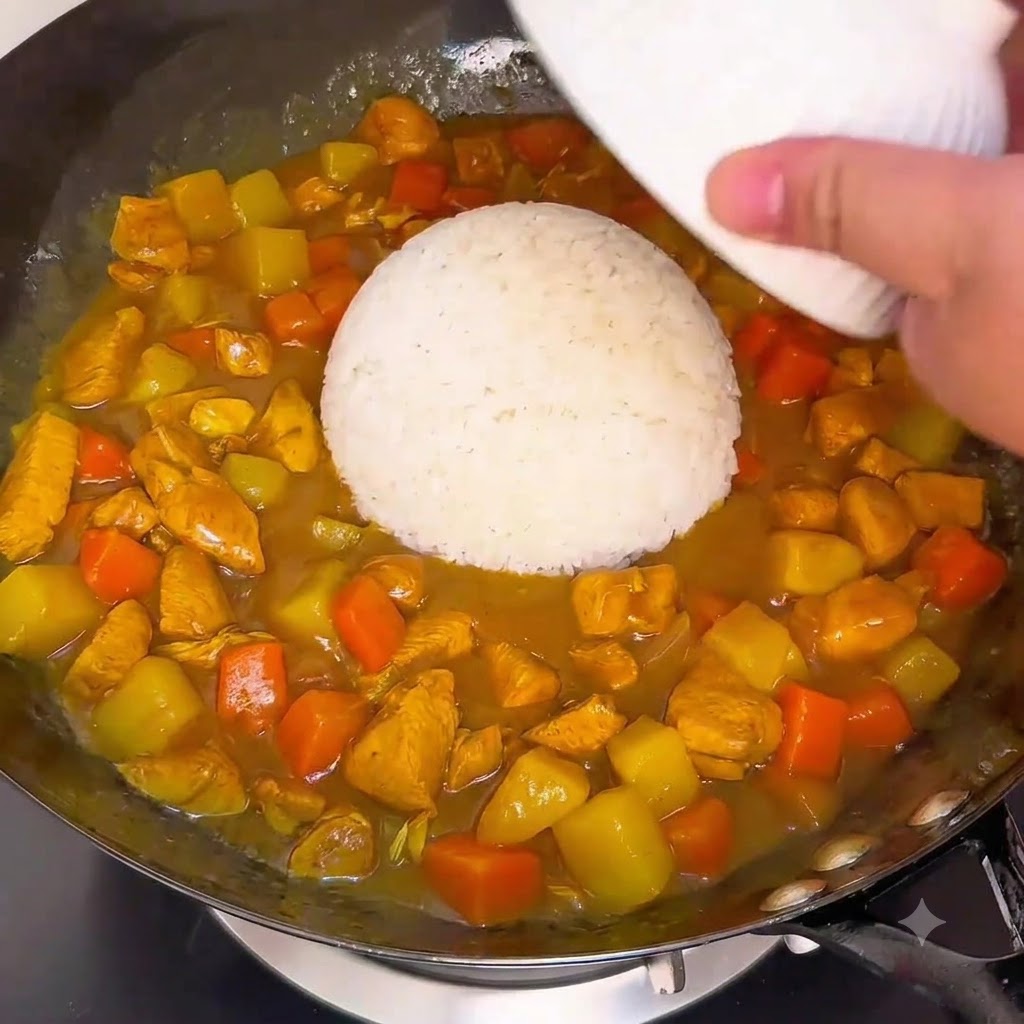 Miska białego ryżu przekładana bezpośrednio do gęstego sosu curry w woku.