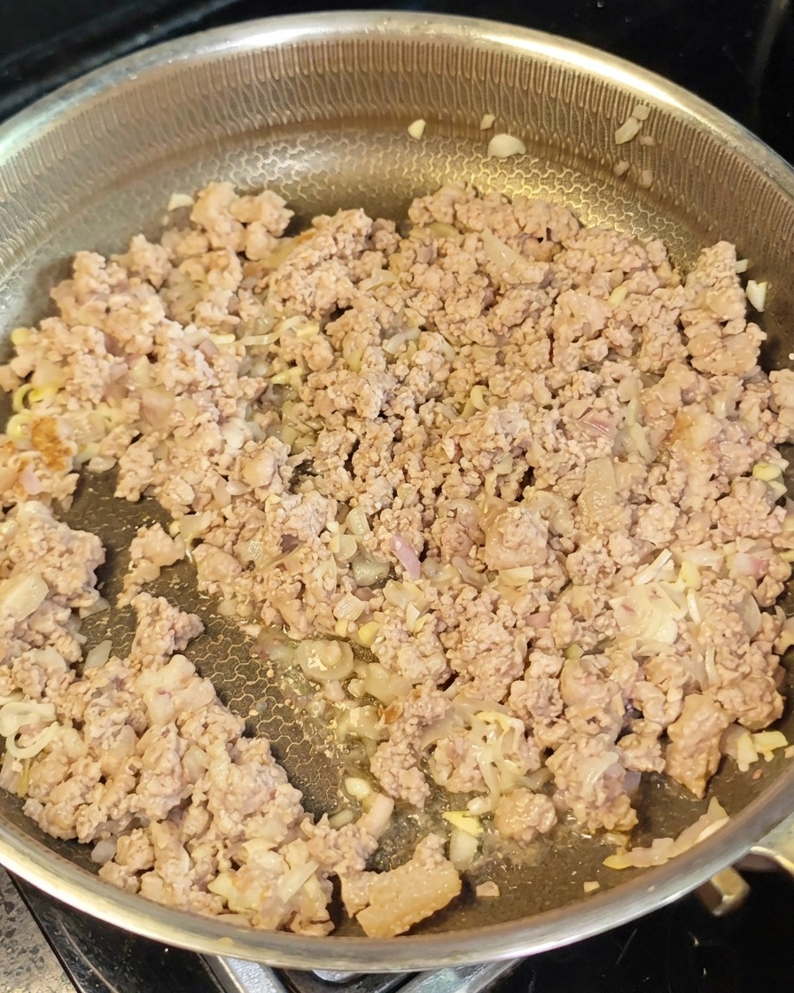 Zrumienione mielone mięso i warzywa rozłożone na patelni wraz z dodawaną pastą z czerwonego miso.