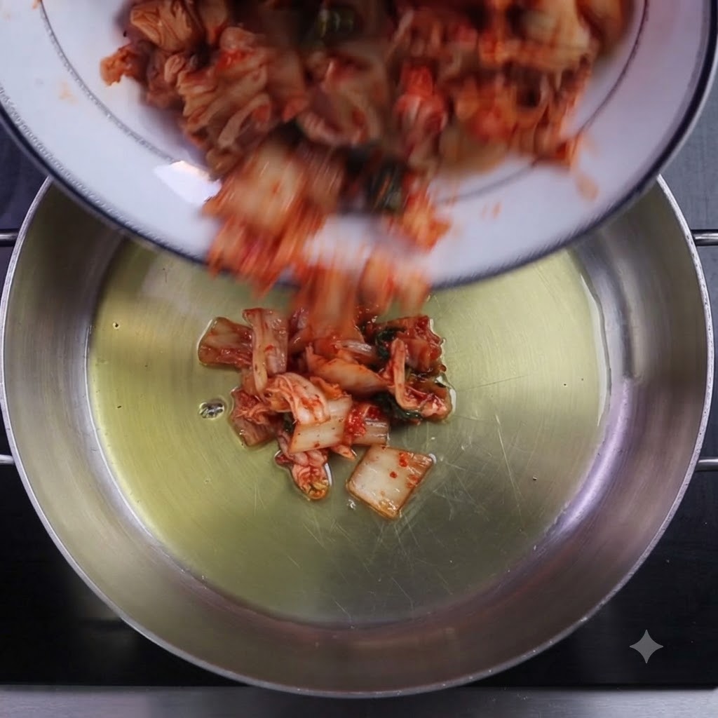 Posiekane kimchi i płatki chili wrzucane do naoliwionego garnka.