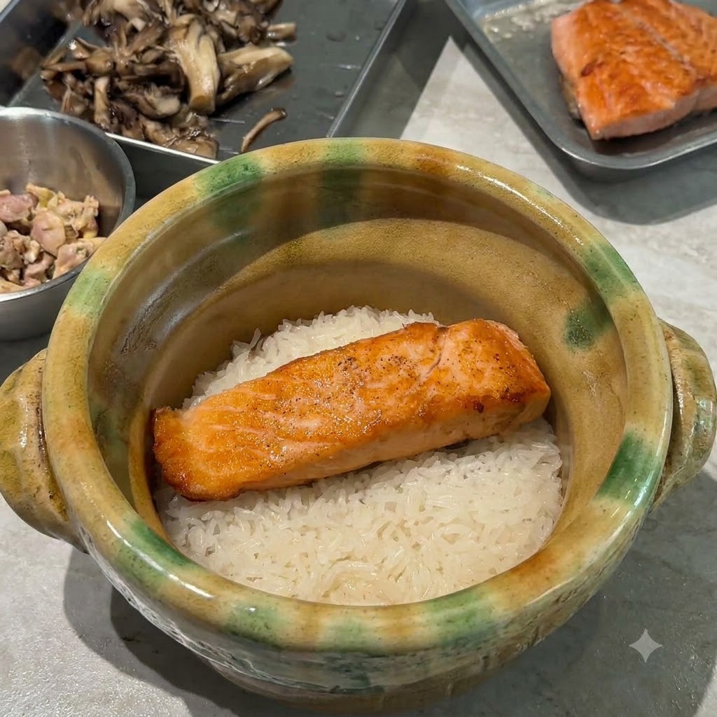 Złocistobrązowe stir-fry grzyby maitake układane na łososiu i ryżu wewnątrz garnka glinianego.
