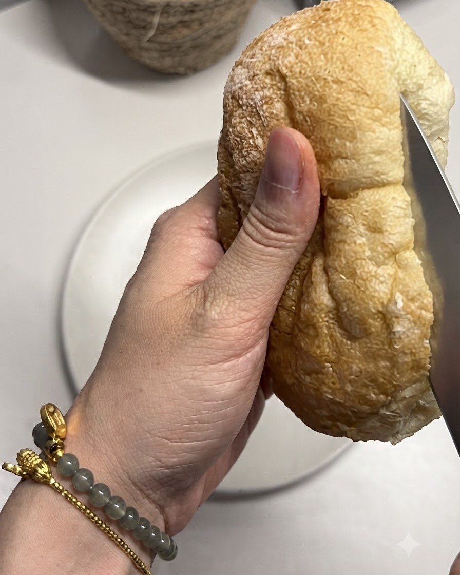Bochenek ciabatty krojony nożem.