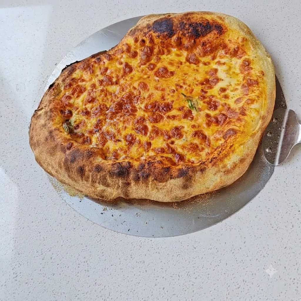 Starty ser mozzarella posypywany na warstwę sosu pomidorowego na cieście.