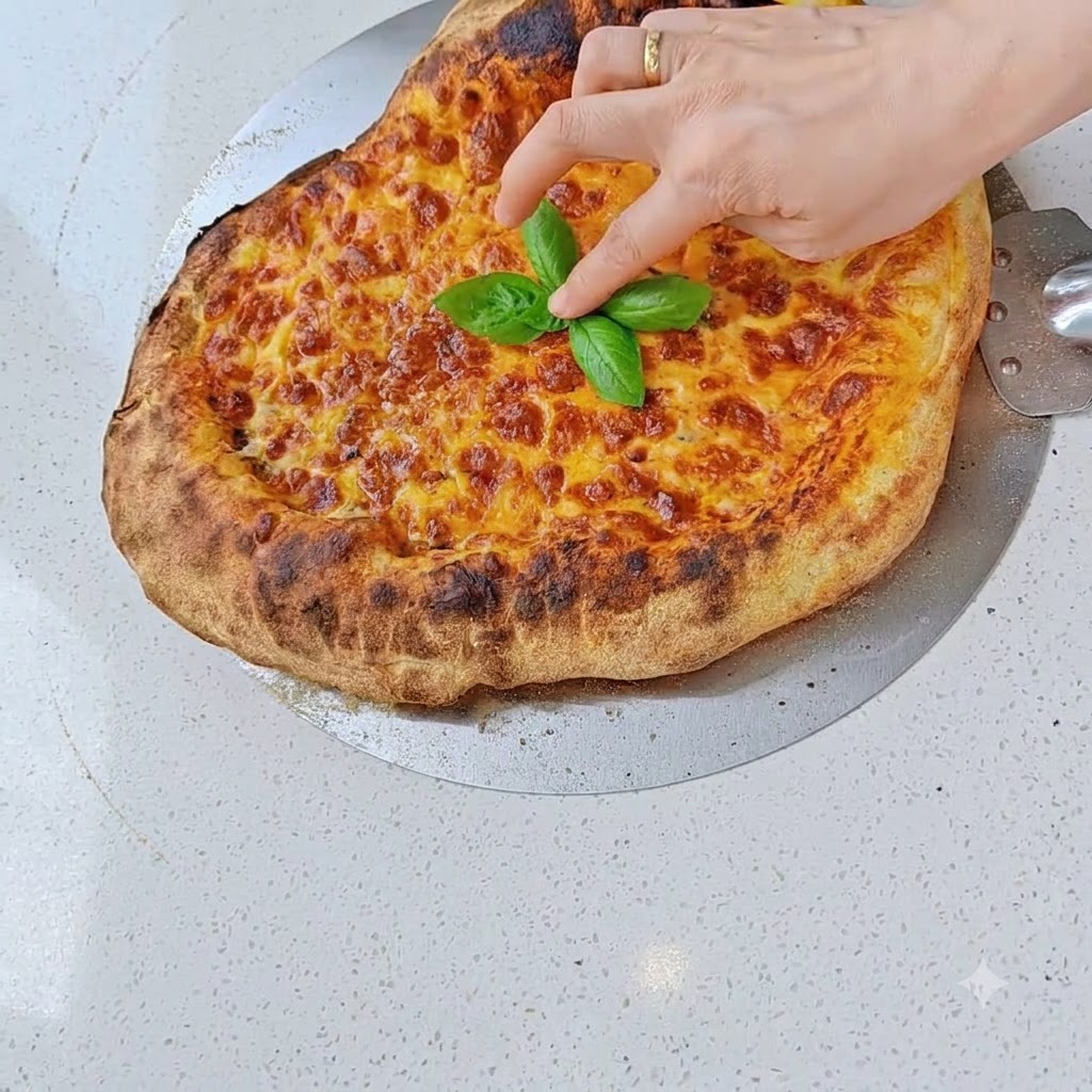 Plastry salami układane na warstwie sera przygotowanej pizzy.