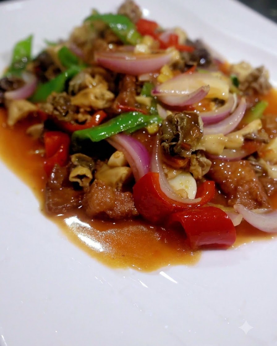 Gotowe danie stir-fry z mieszanych grzybów, papryki, kapusty bok choy i mięsa podane na białym talerzu.