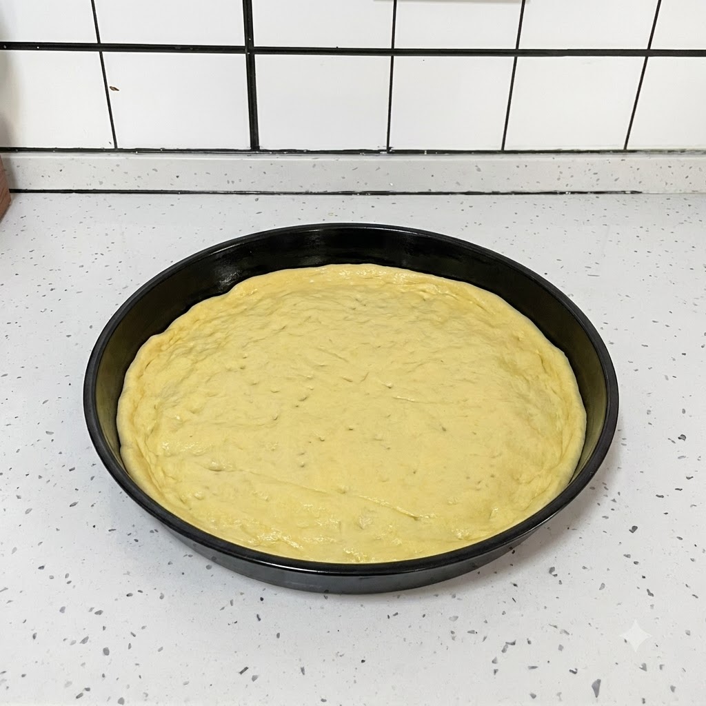 Czarne narzędzie kuchenne używane do nakłuwania małych otworów na spłaszczonym cieście do pizzy w czarnej formie.