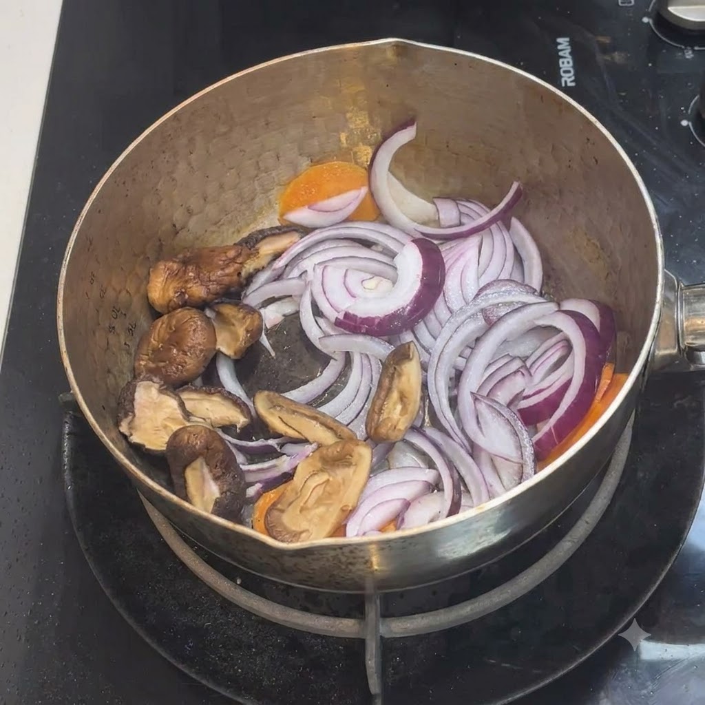 Pokrojone grzyby shiitake umieszczone w garnku z istniejącą mieszaniną cebuli i marchewki.