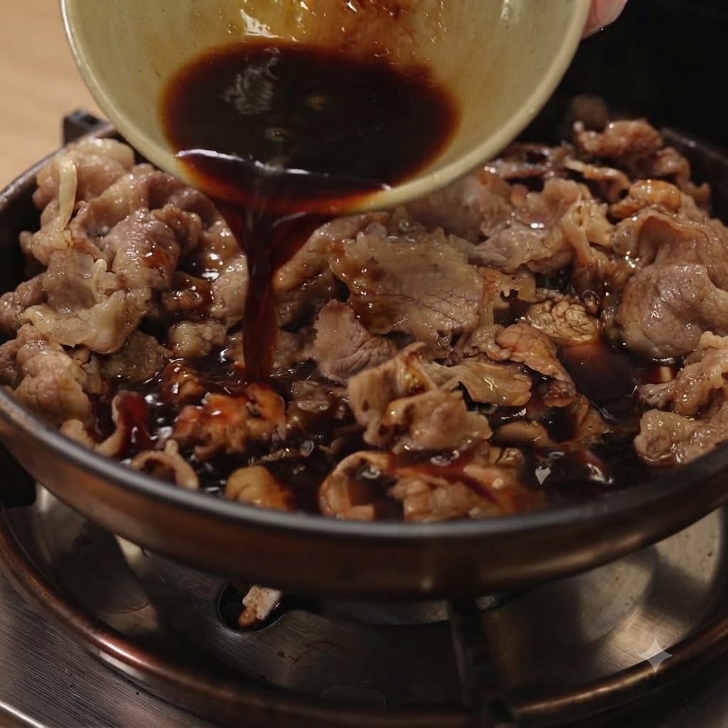 Ciemny sos teriyaki wlewany z małej miseczki na patelnię wypełnioną pokrojoną wołowiną i czerwoną cebulą.