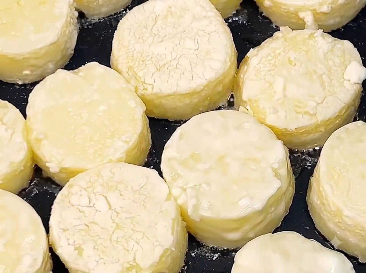 Plastry japońskiego tofu smażące się w gorącym oleju na czarnej patelni, aż ich powierzchnia stanie się złocistobrązowa.