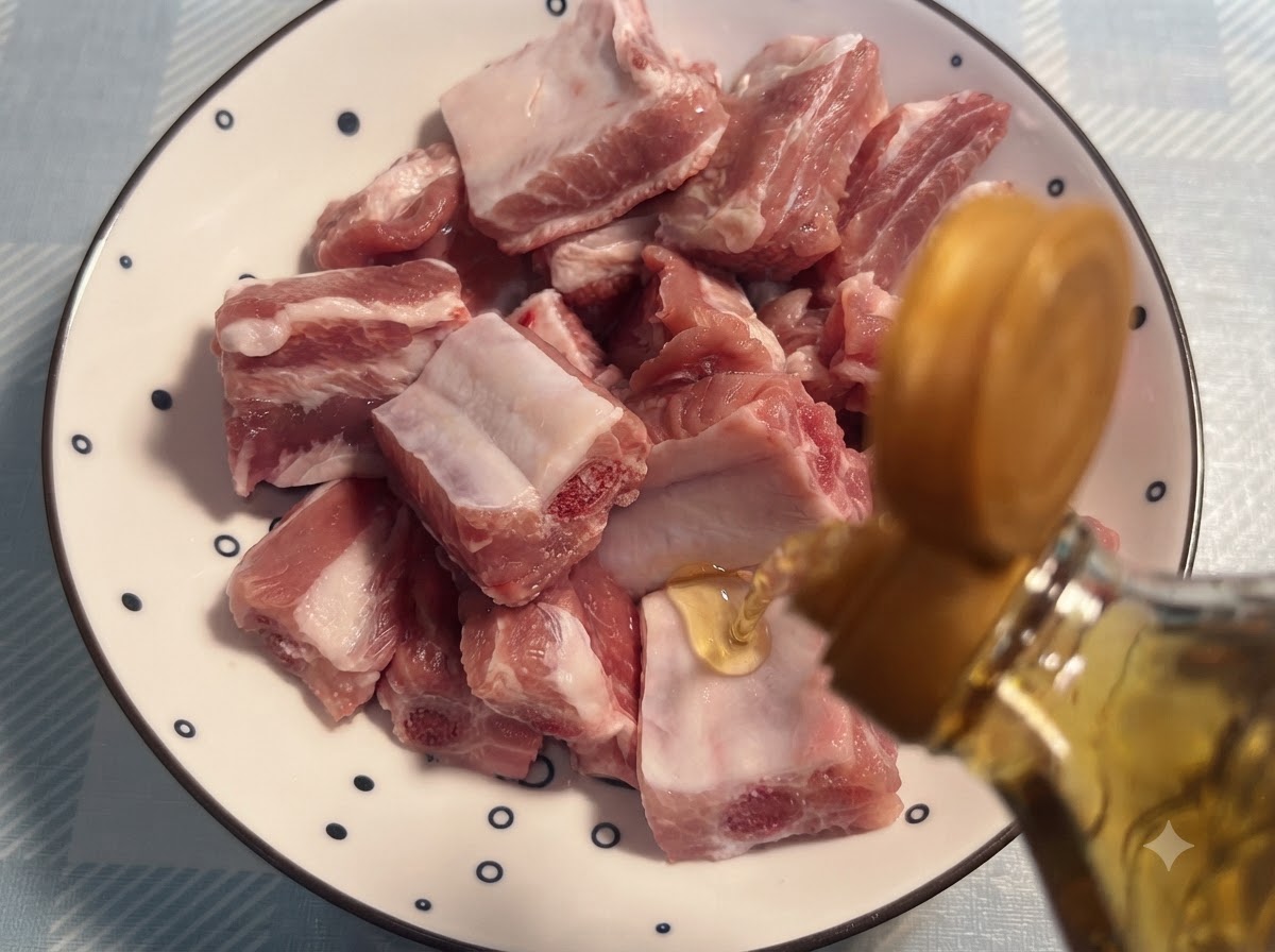 Wino do gotowania nalewane z butelki na surowe żeberka ułożone na wzorzystym talerzu.
