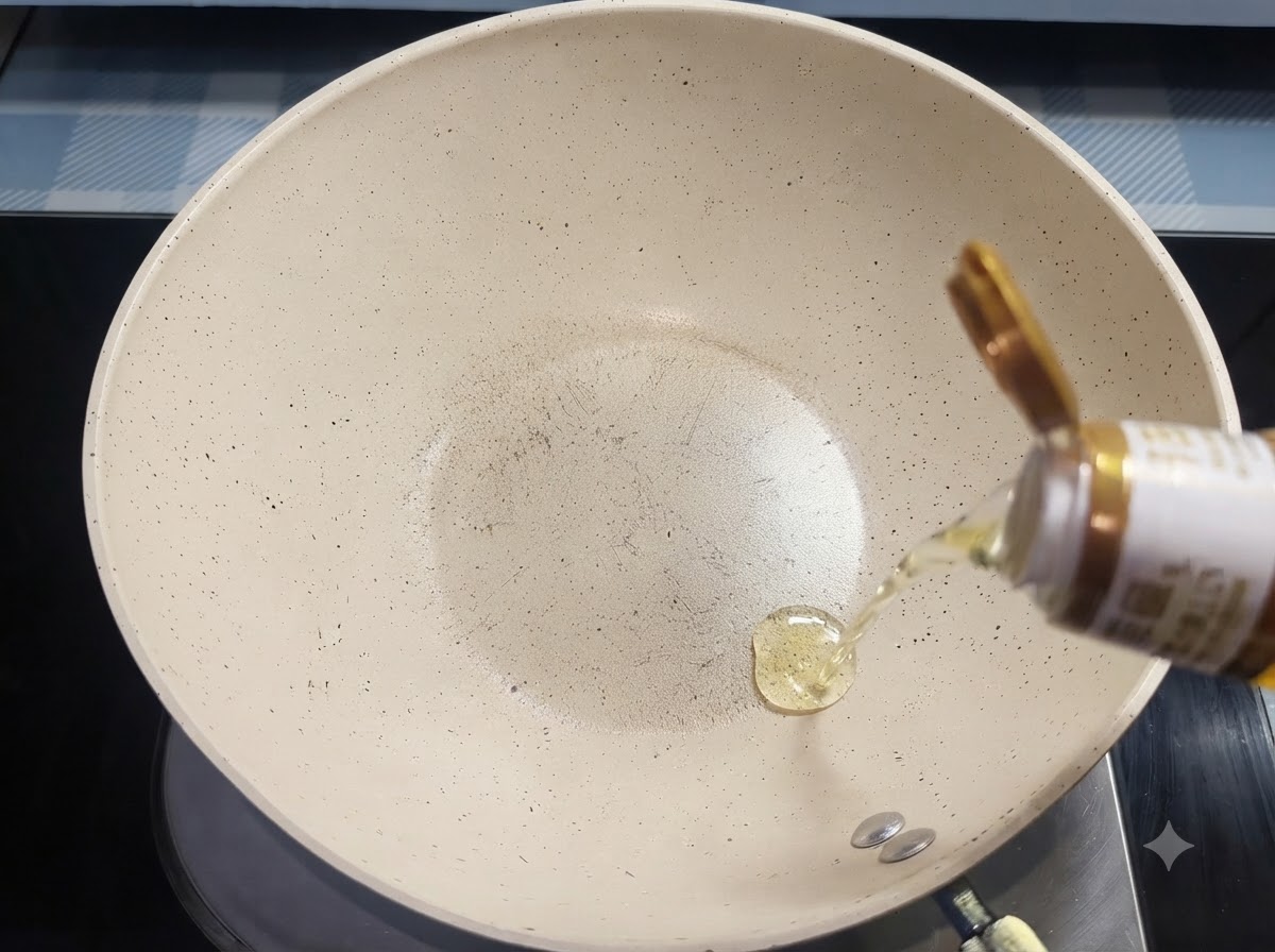 Olej do smażenia wlewany z butelki na białą ceramiczną patelnię.
