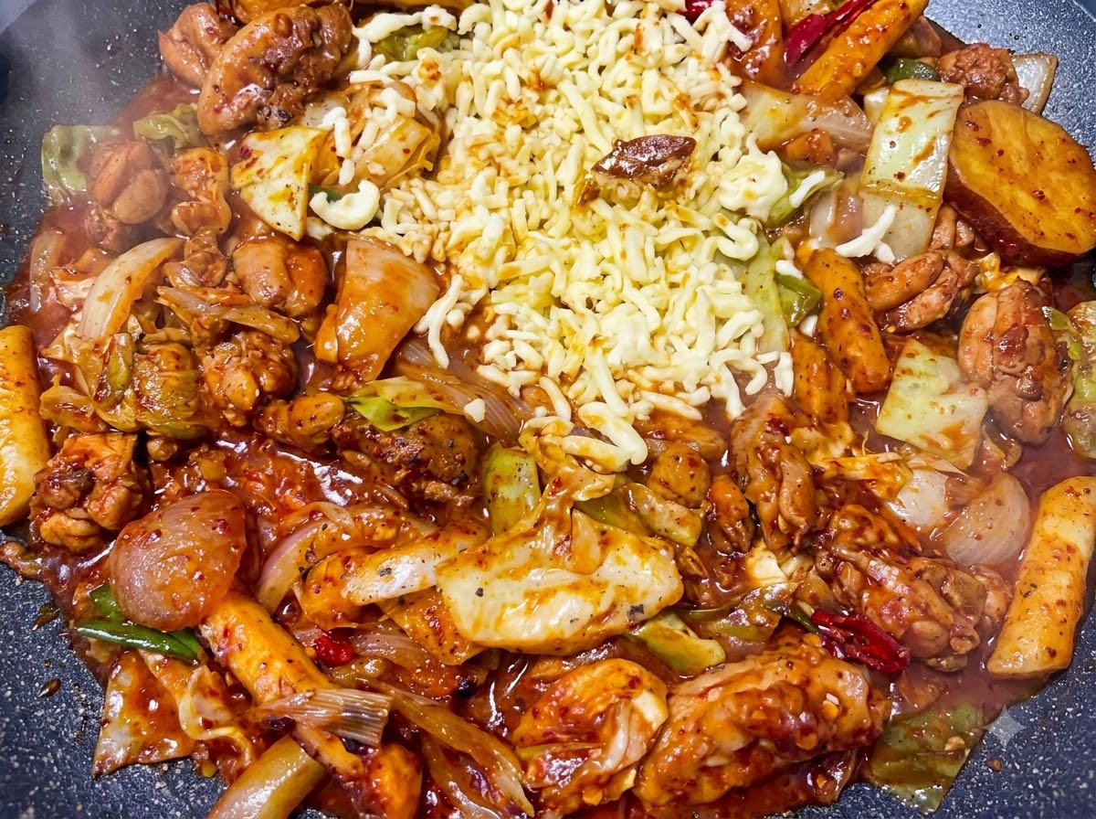 Starta mozzarella wylana w wolną przestrzeń dzielącą na środku bulgoczącego pikantnego stir-fry z kurczakiem.